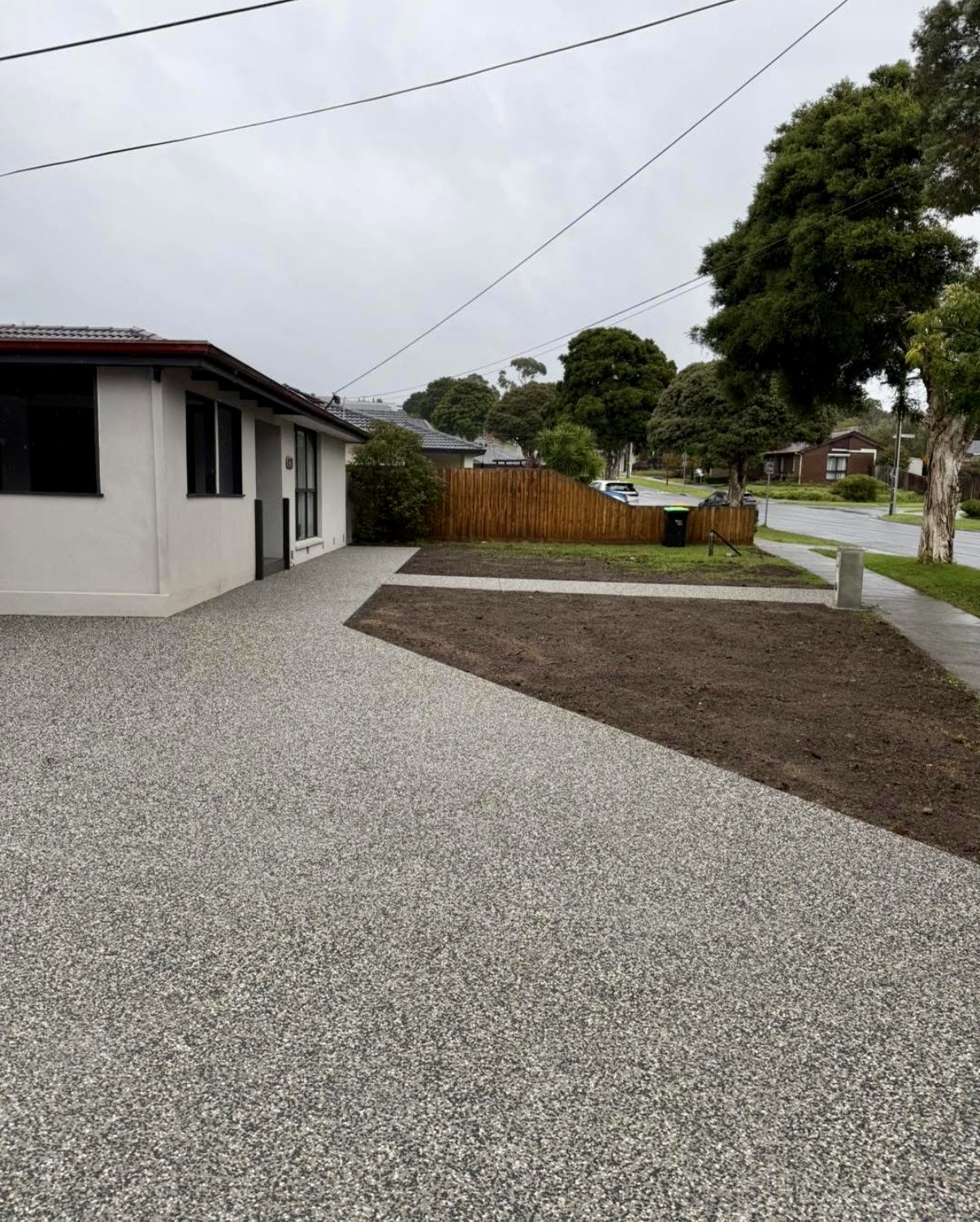 Exposed aggregate concrete driveway and front path at a single-storey rendered home in Melbourne